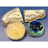 A Mdina glass paperweight with a swirly galactic design, a clear resin paperweight with flower