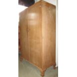 A limed/fumed oak compactum wardrobe "x. c. h. model" enclosed by a pair of plain rectangular