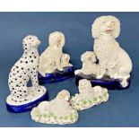 Four 19th century Staffordshire poodles including a facing pair, all with shredded clay finish,