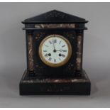 A Victorian black slate and polished marble mantle clock of architectural form enclosing and eight