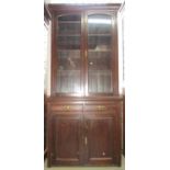 An Edwardian library bookcase, the based enclosed by two panelled doors and two frieze drawer, the