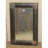 A 1920s hammered copper wall mirror, rectangular enclosing a bevelled edge plate 60 x 38 cm