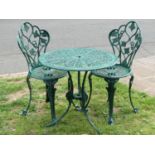 A green painted cast aluminium garden terrace table of circular form with decorative pierced top