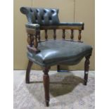 A reproduction office desk chair with green buttoned upholstery, swept back and turned supports