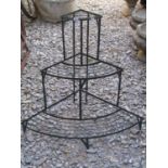 A weathered green painted light steel framed freestanding three tier graduated and bow fronted plant