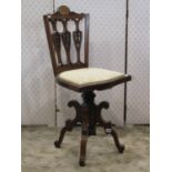 An inlaid Edwardian mahogany music chair with rise and fall swivel adjustable seat, pierced vase