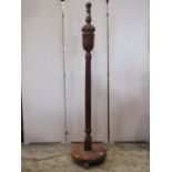 An oak standard lamp with carved and moulded baluster cup and cover and reeded column raised on a