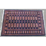 A Turkoman rug with two rows of elephant foot gul on a dark blue ground, 127cm x 80cm.