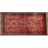 A Hamadan rug with a floral pattern on a rose pink ground. 195cm x 95cm approx