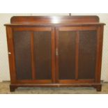 A narrow Edwardian walnut side cupboard in the Georgian style, free standing and enclosed by a