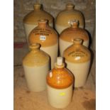 Seven vintage stoneware jars of varying size and capacity with printed and impressed merchants for