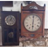 An Edwardian wall clock in an oak case with two train striking movement together with a further