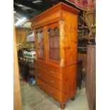 A 19th century stripped and waxed pine two tier cabinet, the lower section enclosed by two long