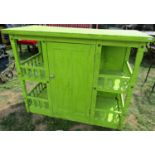 A green painted side cupboard, partially enclosed by a full length central twin panelled door,