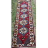 An Anatolian Kazak runner with interlocking medallions of stylised flowers and running floral