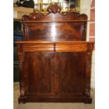 A slim Victorian mahogany chiffonier enclosed by a pair of panelled doors flanked by carved acanthus