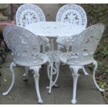 A cream painted cast aluminium garden terrace table of circular form with decorative pierced top