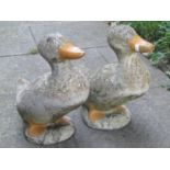Two weathered cast composition stone garden ornaments in the form of ducks in standing pose and head