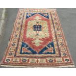A Kazak carpet with good thick wool pile in with central medallion in hues of pink , green and