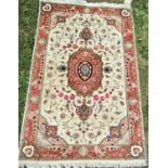 A Tabriz rug a mixture of silk and wool with half a million knots with a central pink scrolled