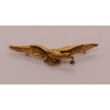 Gilt metal RAF eagle brooch with articulated diamond held from its beak, stamped 'FIX' to reverse,