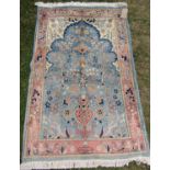 A mid 20th century Persian Qum rug with a signature with pink flowers on a pale blue ground, 150cm x