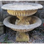 A pair of weathered cast composition stone garden urns, the shallow circular lobed bowls with flared