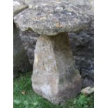 A weathered natural stone staddlestone of square tapered form with domed cap, approx 60cm diameter x