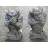 Two similar composition stone gargoyle ornaments with shield and celtic knot detail, 38 cm high