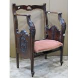An Edwardian patent music chair with adjustable seat, carved frame and scrolled toes
