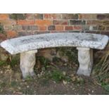 A painted and weathered cast composition stone three sectional garden bench, the curved slab seat