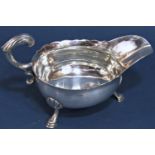 A Georgian silver sauce boat, London 1750, maker John Pollock, with scrolled handle raised on pad