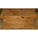 A low stripped pine box with twin hinged lid raised on stepped and moulded bracket feet, 95 cm
