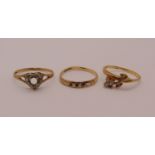 Three gold rings; a 14ct floral example set with white stones, a 9ct heart shaped example and a