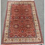 A Persian design carpet with an all over floral pattern on a red ground, 230cm x 150cm approx