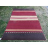 A modern wool carpet with abstract red brown and yellow striped pattern, 230cm x 160cm approx.