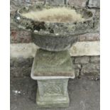 A weathered cast composition stone garden urn, the circular lobed bowl with flared rim and
