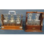 An Edwardian oak tantalus with silver plated handle and three cut glass decanters, each with a