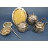 An Indian silver metal three piece tea service, richly engraved and embossed, a similar bowl, a