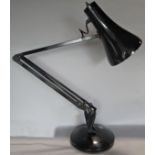 A black enamel anglepoise lamp on a circular base