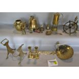 A collection of brass ware including a brass bell, miners lamp, andirons, horse brasses, trivet