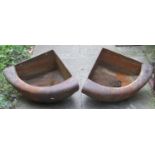 A pair of weathered cast iron bow fronted and wall mounted corner stable troughs 65 cm wide x 47