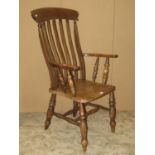 A 19th century Windsor lathe back elbow chair in elm and beech