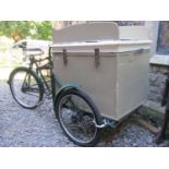 A vintage three wheeled tradesman cycle with green painted tubular steel frame and sprung leather