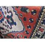A Kazak rug with an expanded hooked central medallion on a cream field, 210cm x 127cm approx