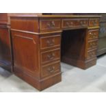 A reproduction yew wood veneered kneehole twin pedestal desk in the Georgian style with inset sage