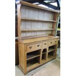 A 19th century stripped pine kitchen dresser, the base fitted with three frieze drawers over open