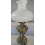 A 19th century brass oil lamp with engraved font, with an opaque white shade, lacks chimney.