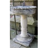 A weathered cast composition stone two sectional sun dial with repeating flower head and rope