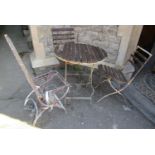 A weathered folding ironwork framed garden terrace/cafe table with circular wooden slatted top